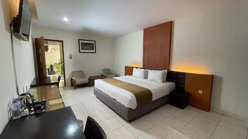 una camera d'albergo con un letto e una scrivania di LPP Convention Hotel Demangan a Yogyakarta