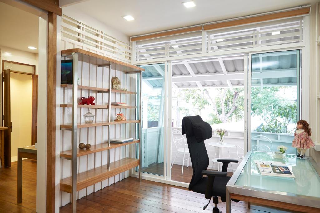 a room with a desk and a chair and a window at Uncle Loy's Boutique House in Bangkok