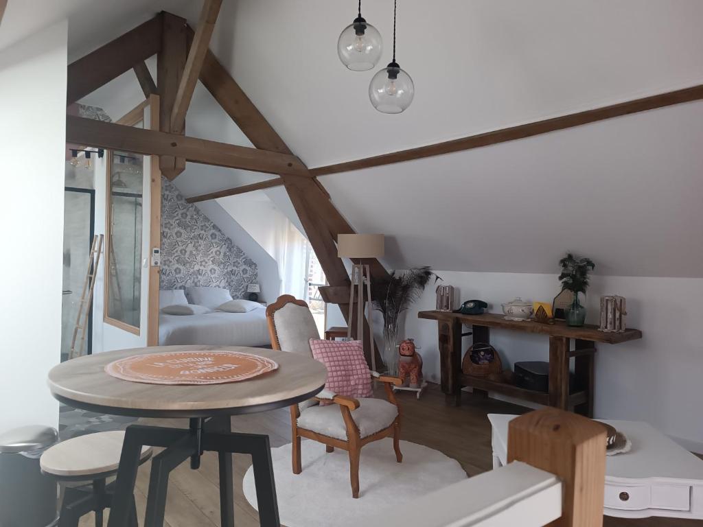 a room with a table and chairs and a bed at La Réserve, Suite et SPA in Noyelles-sous-Bellonne