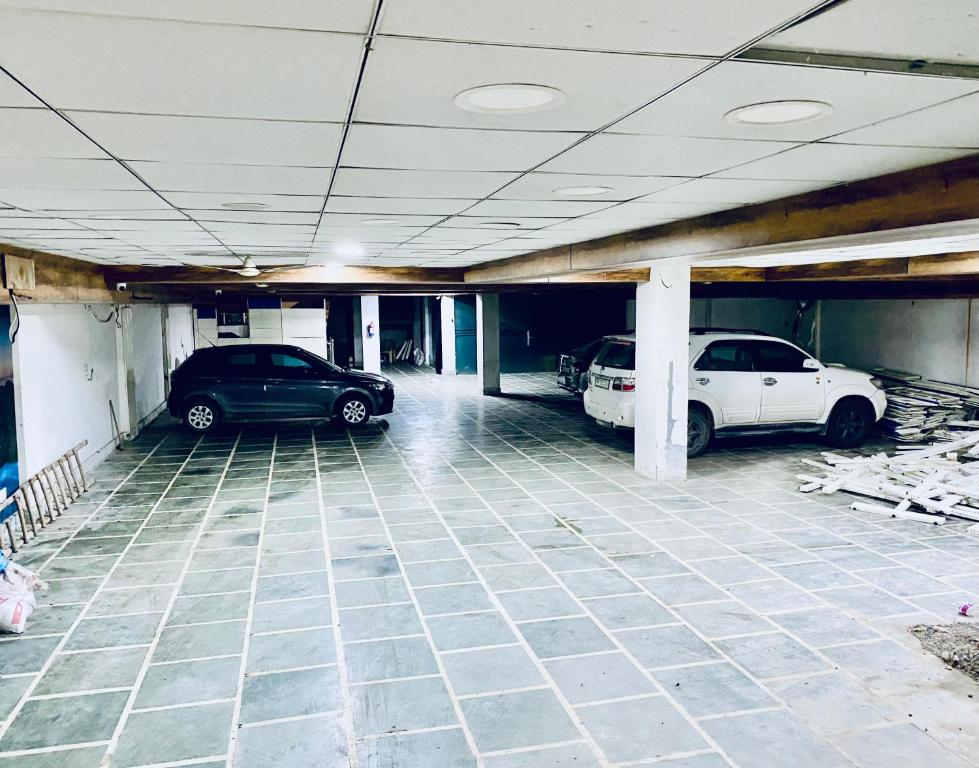 a parking garage with two cars parked in it at Mewar Lodge in Varanasi