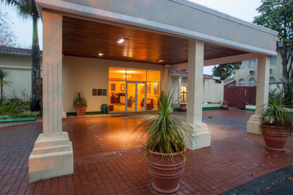 un bâtiment avec des plantes en pot sur une terrasse en briques dans l'établissement Mountain View International by BON Hotels, à Mbabane