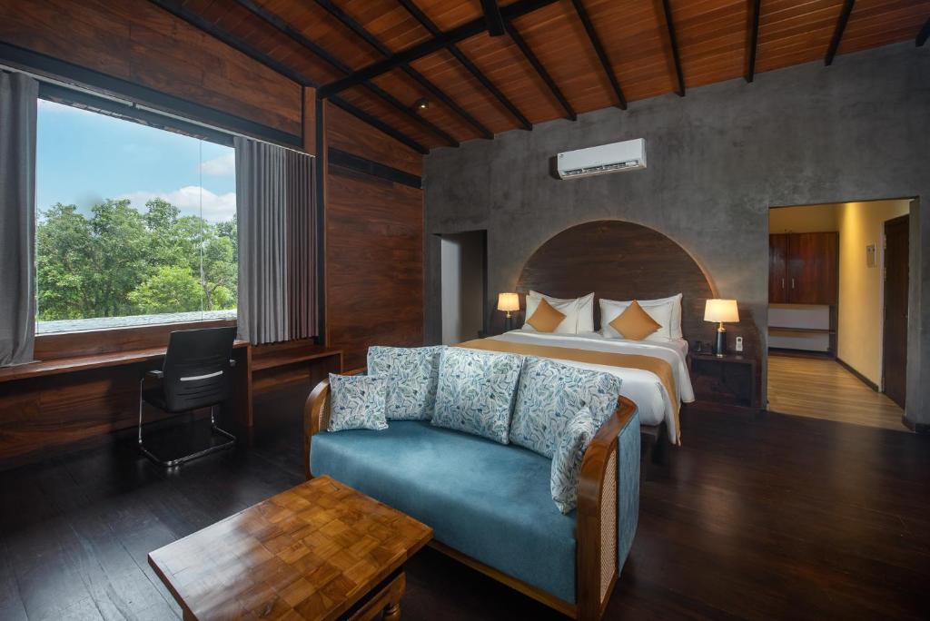 una camera da letto con un letto, un divano e una finestra di Atha Resort a Sigiriya