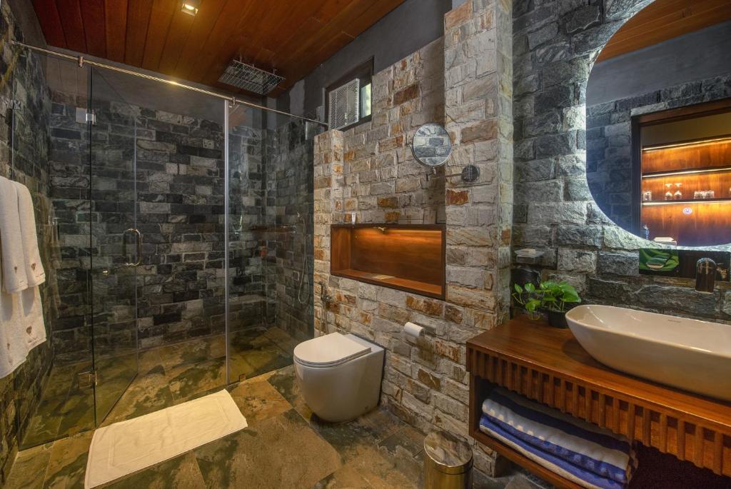 un bagno con lavandino, wc e doccia di Atha Resort a Sigiriya