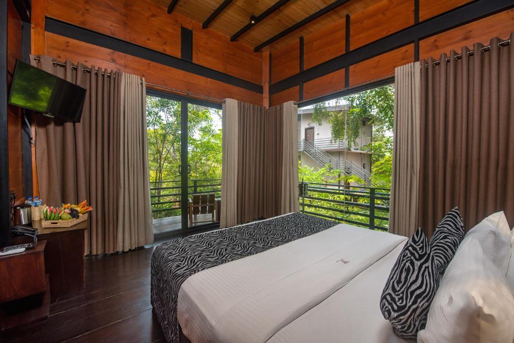 una camera da letto con un letto e una grande finestra di Atha Resort a Sigiriya