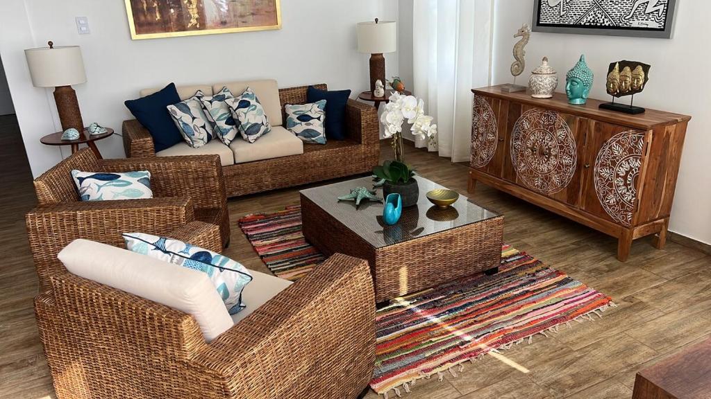 a living room with wicker couches and a table at Dolphin beach house in San Antonio