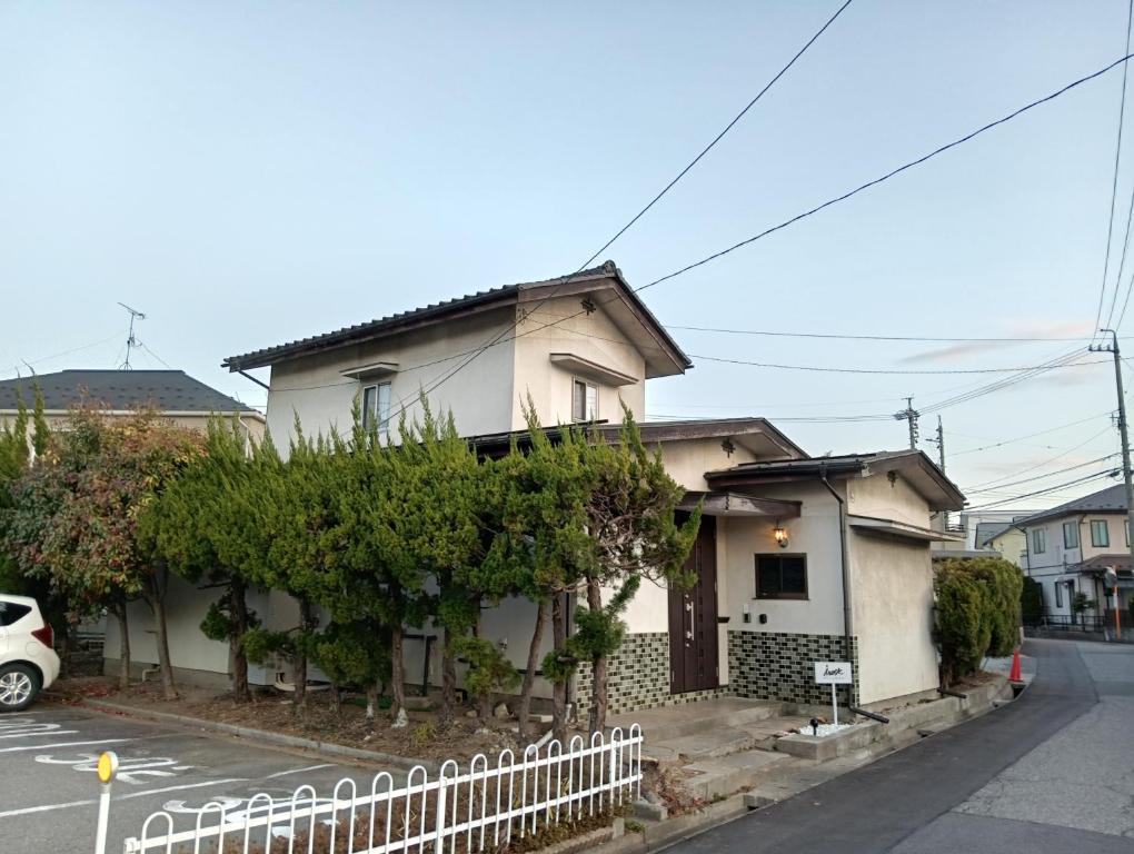 una casa bianca con una recinzione davanti di Irest Village Matsumoto 2 a Matsumoto