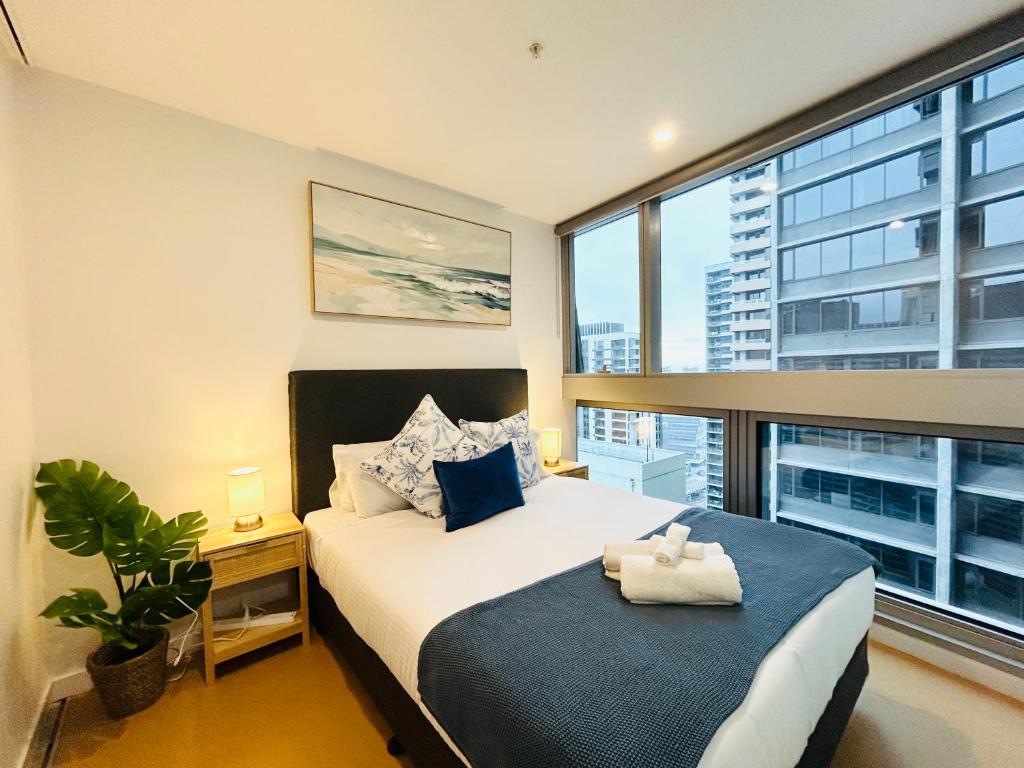 a bedroom with a large bed and a large window at The Escape in Southern Cross Station in Melbourne