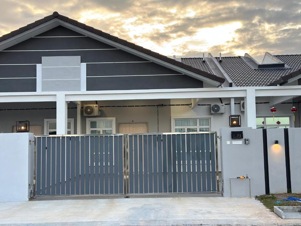 a house with a gate in front of it at De Home Kluang Homestay in Kluang