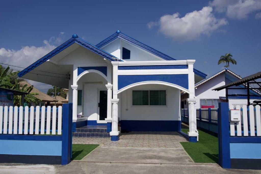a blue and white house with a white fence at Crypto Home in Ban Mae Mao
