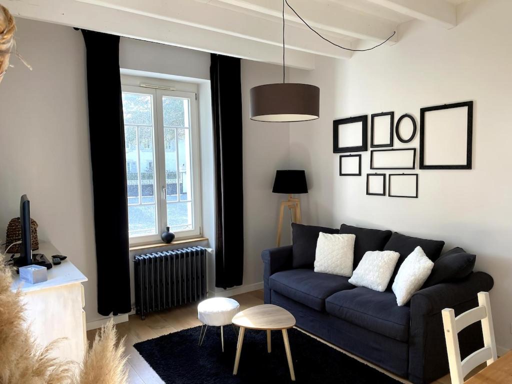 un salon avec un canapé bleu et une fenêtre dans l'établissement Appartement 4 étoiles dans propriété classée, à Capbreton