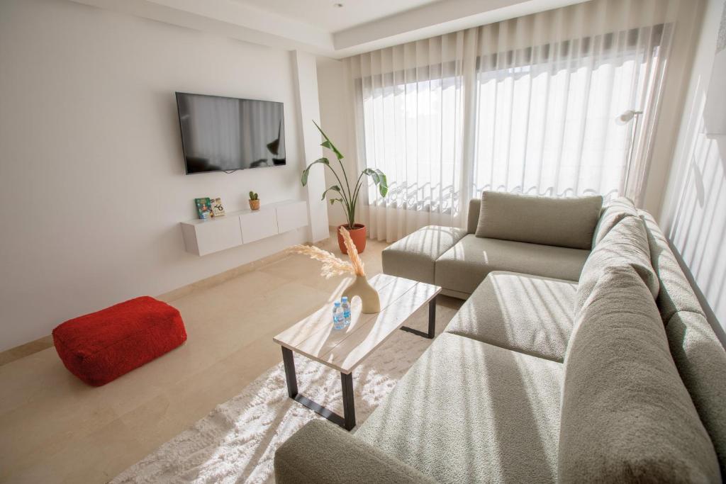 ein Wohnzimmer mit Sofa und Tisch in der Unterkunft Haut Standing 2-Bedroom Apartment in Gauthier in Casablanca