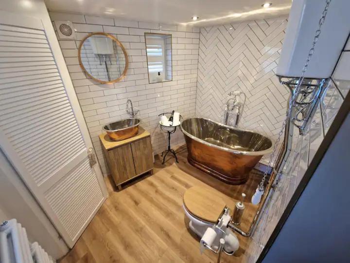 a bathroom with a large tub and a sink at Gable Cottage - Staindrop - Copper Bath - Logburner in Staindrop