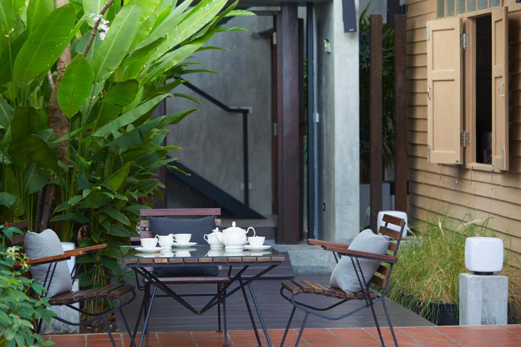 a patio with a table and chairs and plants at Uncle Loy's Boutique House in Bangkok