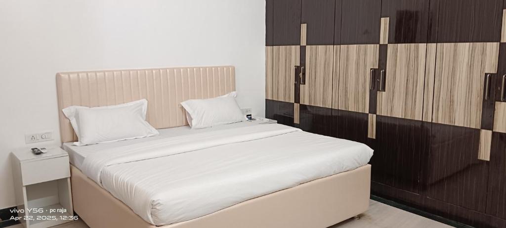 a bedroom with a large white bed with wooden cabinets at The Ashish Luxury Stay in Chittaurgarh