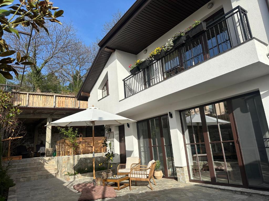 a building with a patio with an umbrella and chairs at Stylish Two Bedroom Family Villa in Sopot