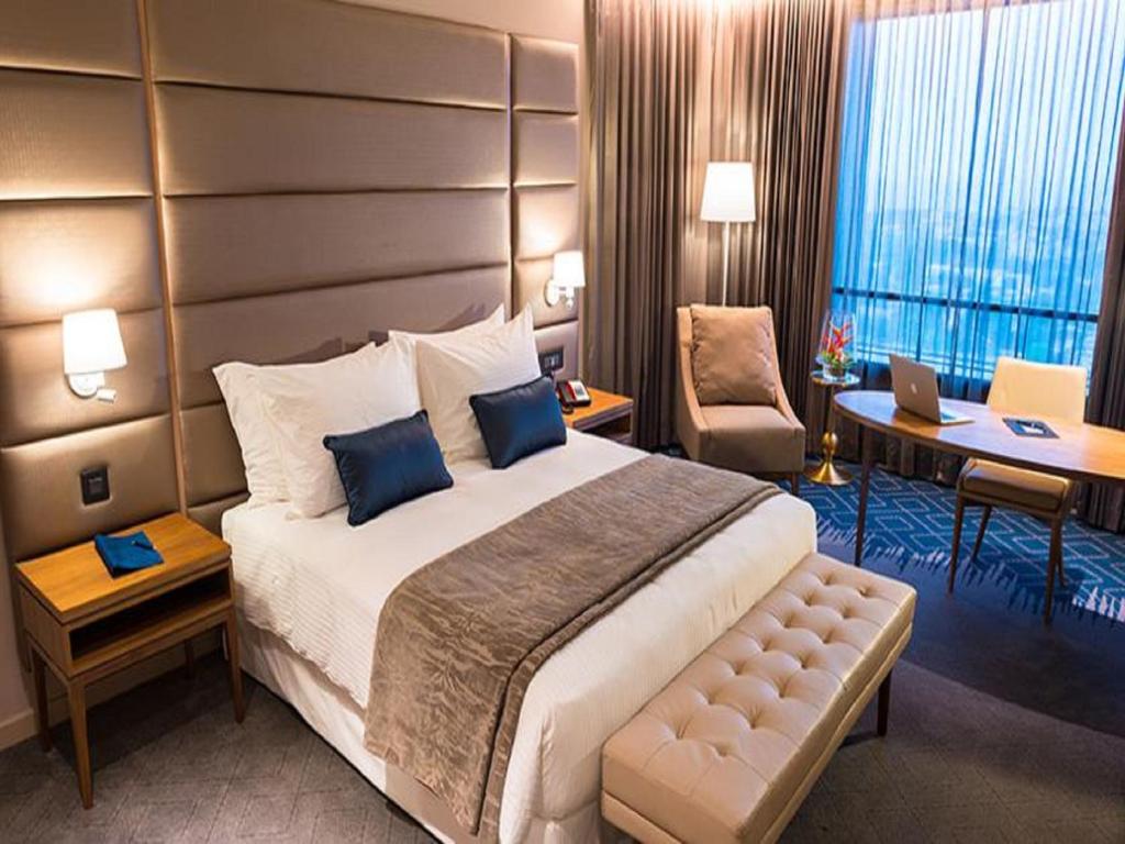 a hotel room with a large bed and a desk at Hotel 2 Fevrier, Lomé in Lomé