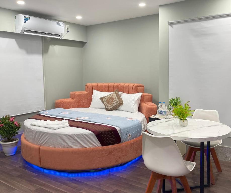 a bedroom with an orange bed with a table and chairs at Hotel Family Inn near Airport Uttara, Dhaka in Dhaka
