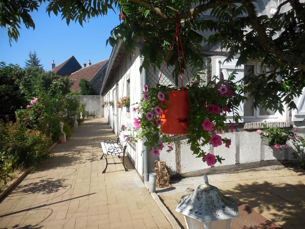 a house with flowers hanging from the side of it at Les rouches in Cormeray