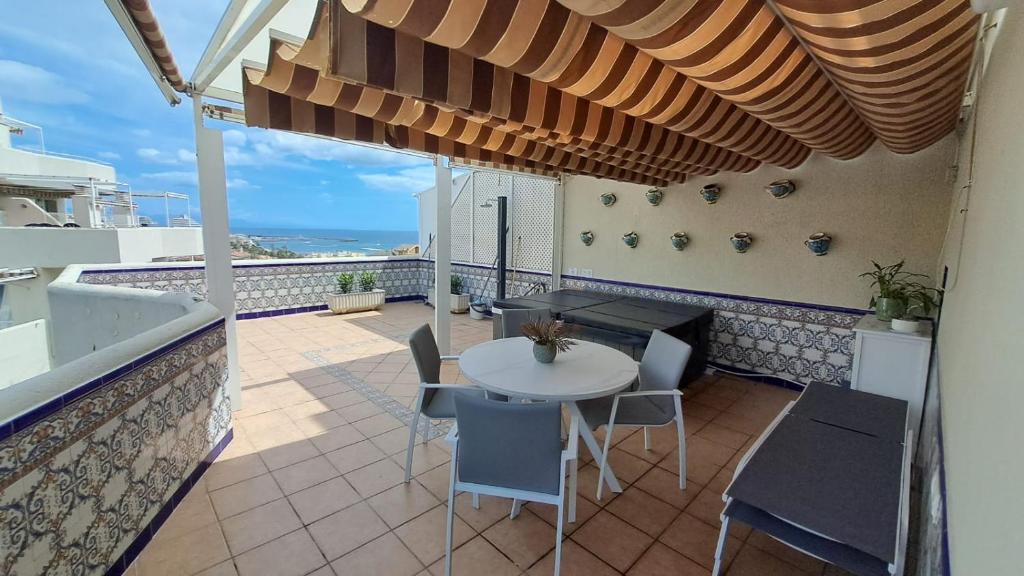 Un patio con una mesa y sillas en un balcón. en Benalbeach Magic View, en Benalmádena