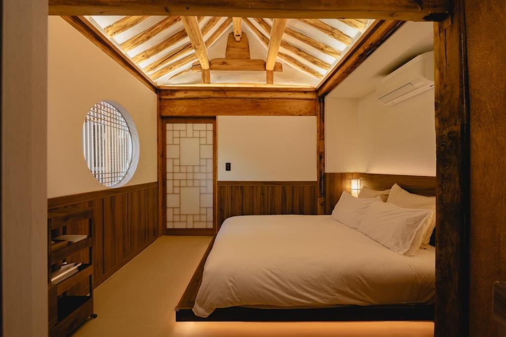 sypialnia z łóżkiem i drewnianym sufitem w obiekcie HWAYEONJAE, Private Hanok Luxury Live Tradition in Bukchon w Seulu