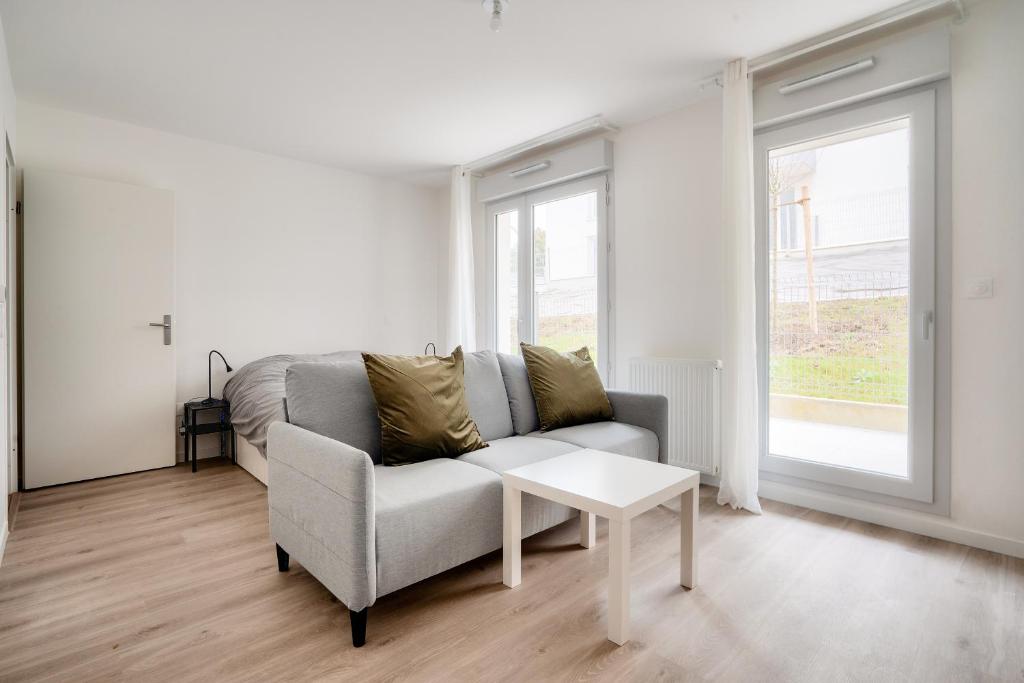 un salon avec un canapé et une table dans l'établissement Cosy studio à Rosny-sous-Bois, à Rosny-sous-Bois