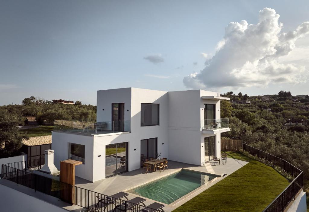 ザキントスにあるAkra Villa, a Cliffside Escape with Pure SeaViews, By ThinkVillaのスイミングプールとバルコニー付きのホワイトハウスです。
