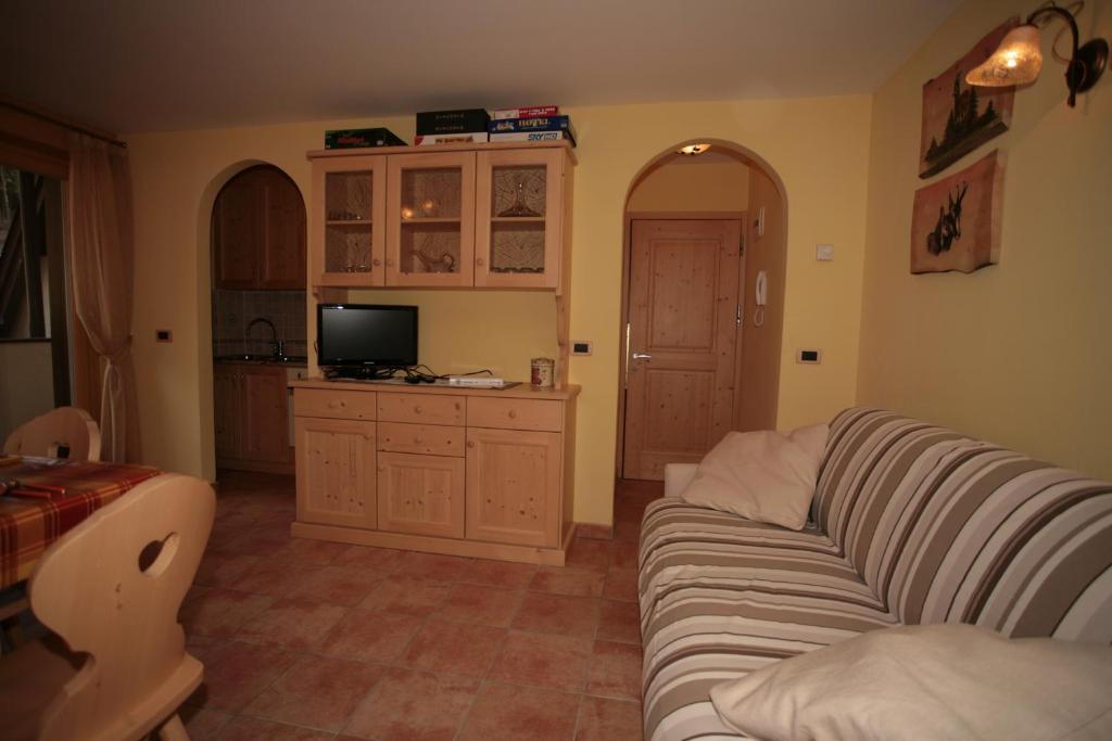 een woonkamer met een bank en een tv bij Appartamenti Cercenà Deluxe in Canazei