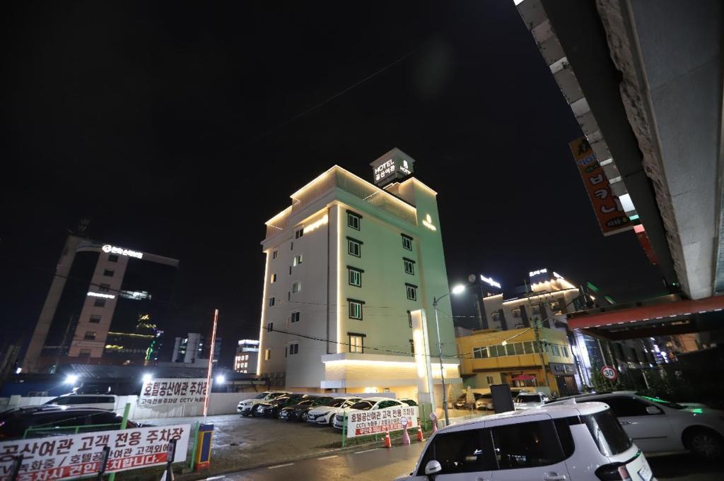 a tall white building with a clock on top of it at Hotel Gongsan in Gongju