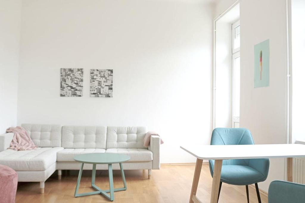 a living room with a white couch and a table at Apartment Two am Stadtpark in Villach