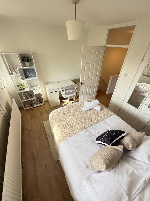 a bedroom with two beds and a table and a chair at Luxury 3BDR apartment in King’s cross in London