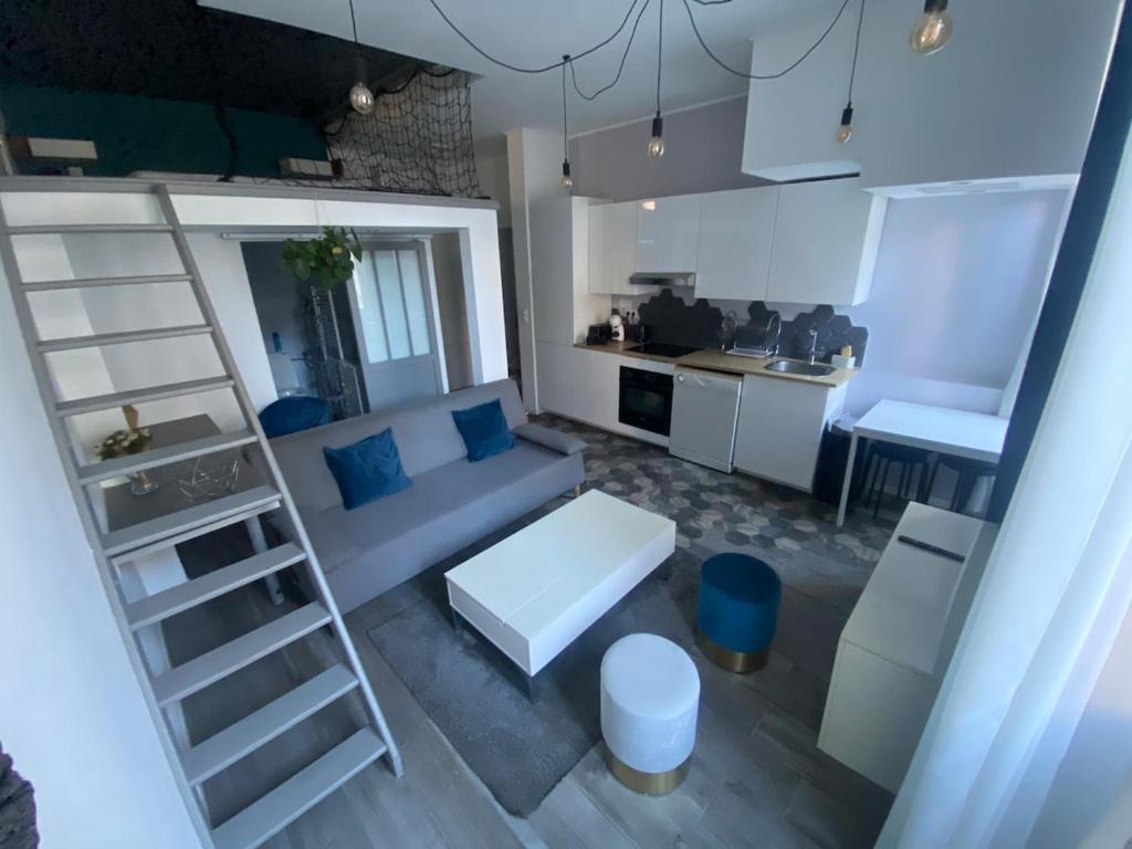 un salon avec un canapé bleu et une échelle dans l'établissement Cosy Cottage by Alice Marseille Centre & Plage, à Marseille