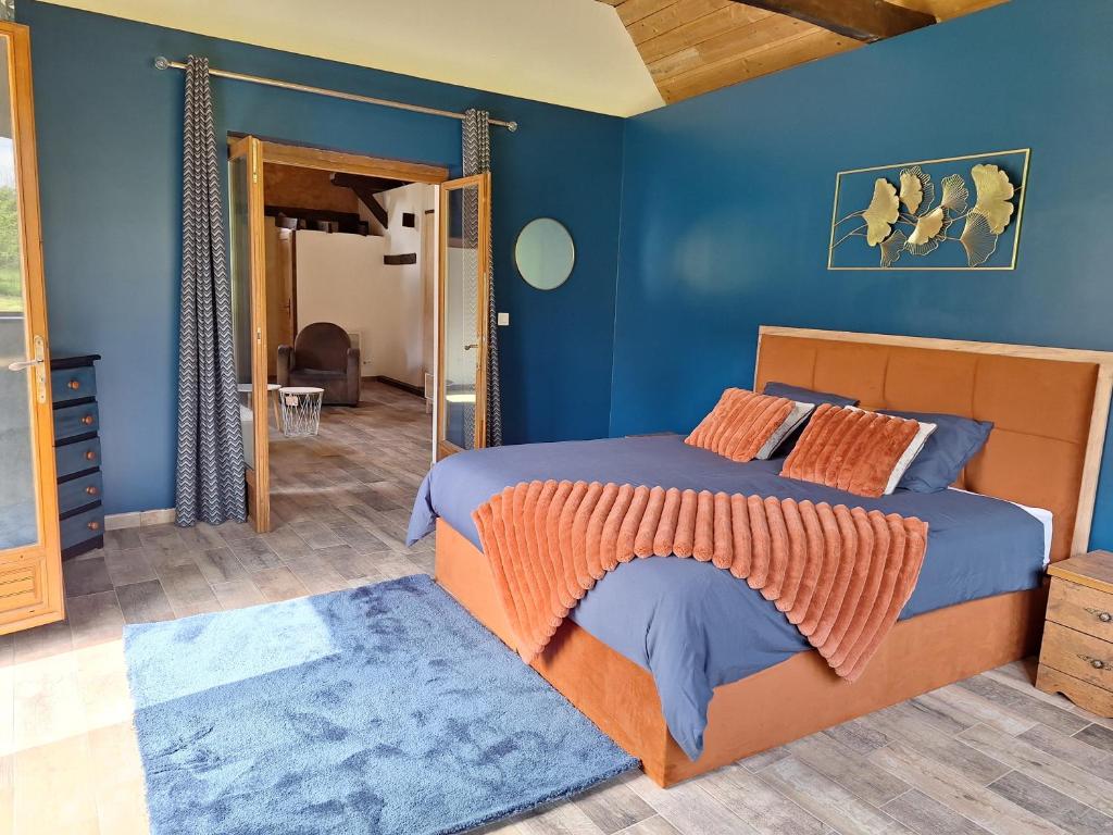 une chambre avec un lit et un mur bleu dans l'établissement Environnement exceptionnel, à Coulans-sur-Gée