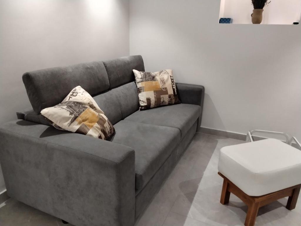 a gray couch with pillows on it in a living room at Old Town Baska in Baška