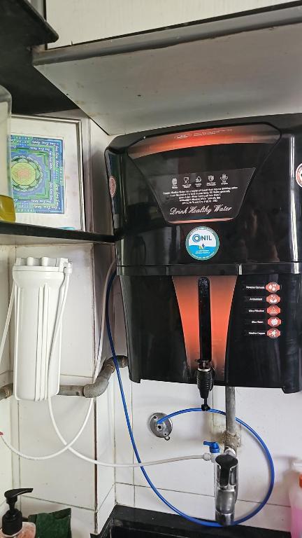 a microwave with a blue hose hooked up to it at Laxmi Happy Home in Pune in Pune
