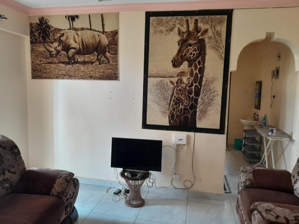 a living room with pictures of animals on the wall at aphyl homes in Mombasa