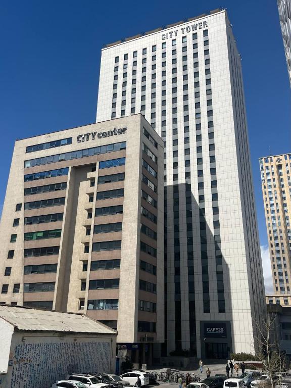 a tall building with cars parked in front of it at City Tower Hotel in Ulaanbaatar