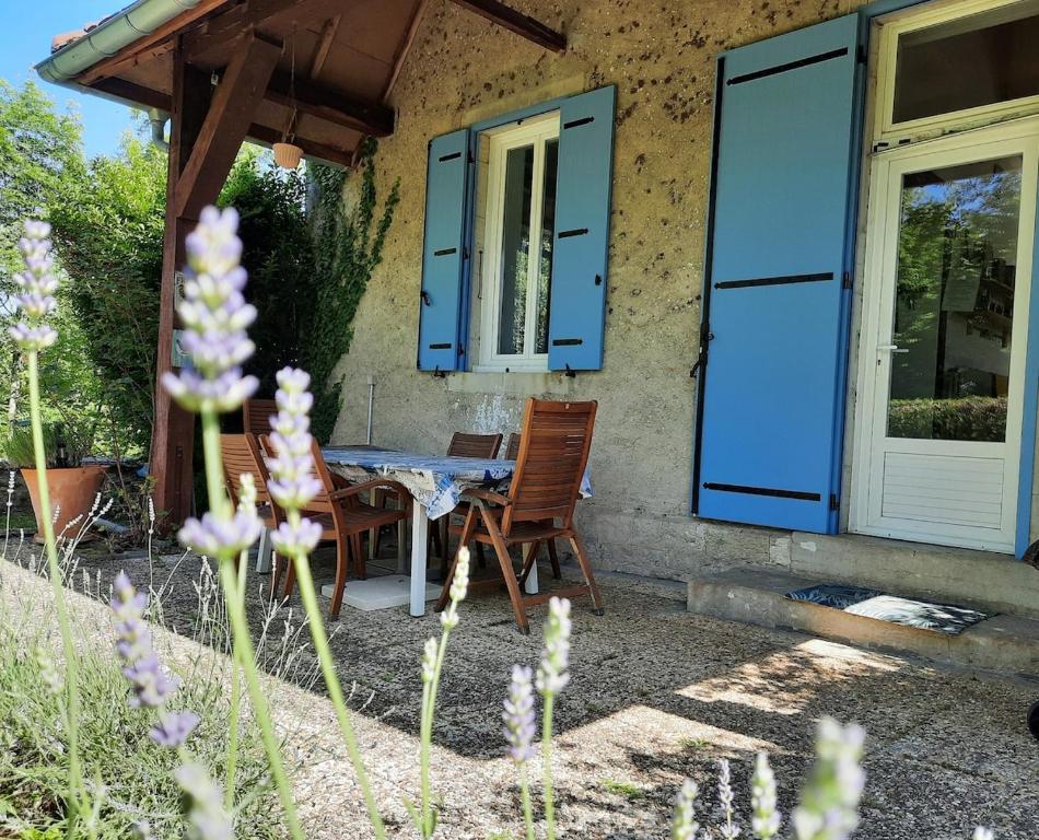 une table et des chaises devant une maison dans l'établissement La Maison Bleue Ancienne Ecole, à Sarrogna