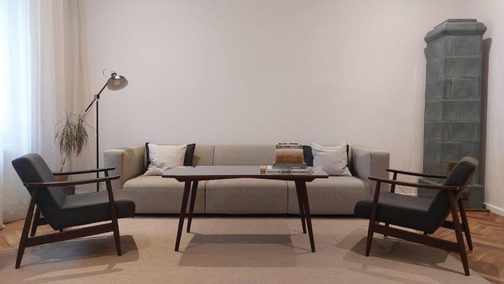 een woonkamer met een bank, een tafel en twee stoelen bij The WEST NEST in Zagreb