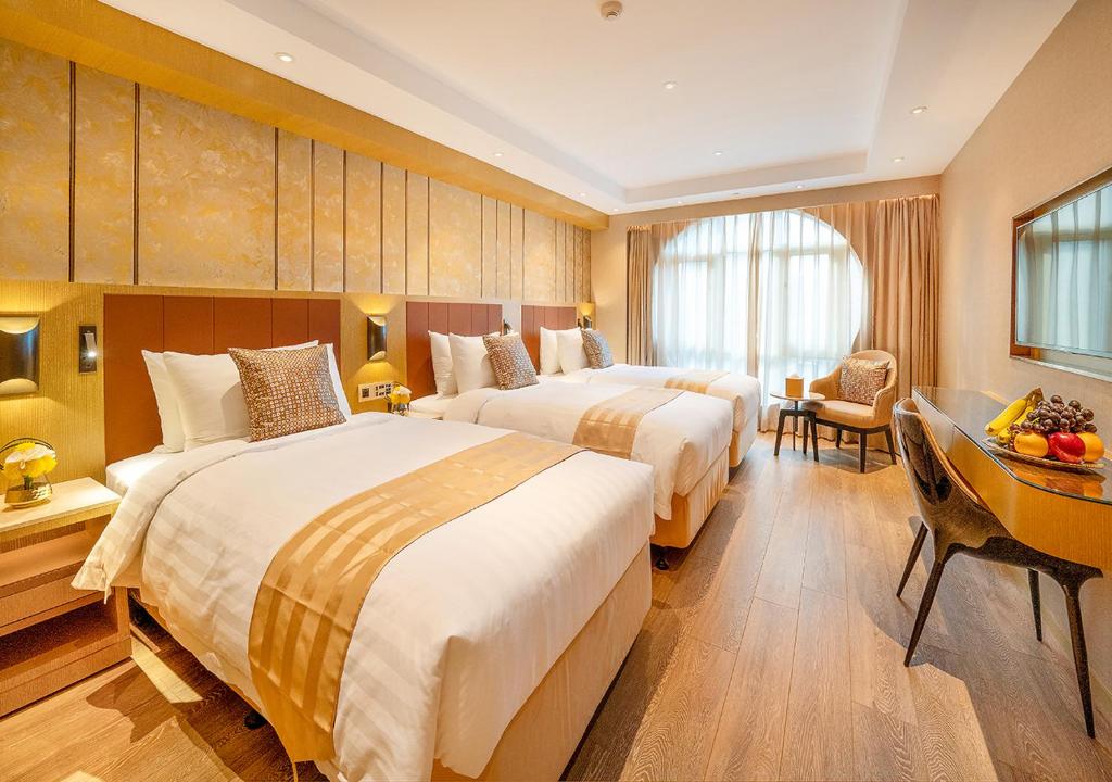 Postel nebo postele na pokoji v ubytování Grand Dragon Hotel