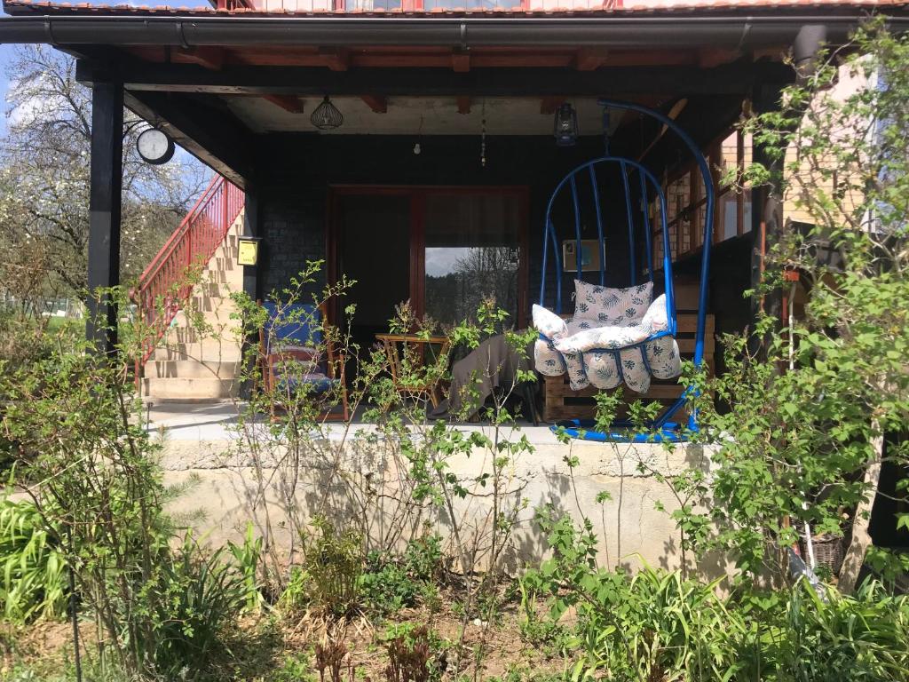 a house with a porch with a bench in front of it at Kokin Brod Apartments in Kokin Brod