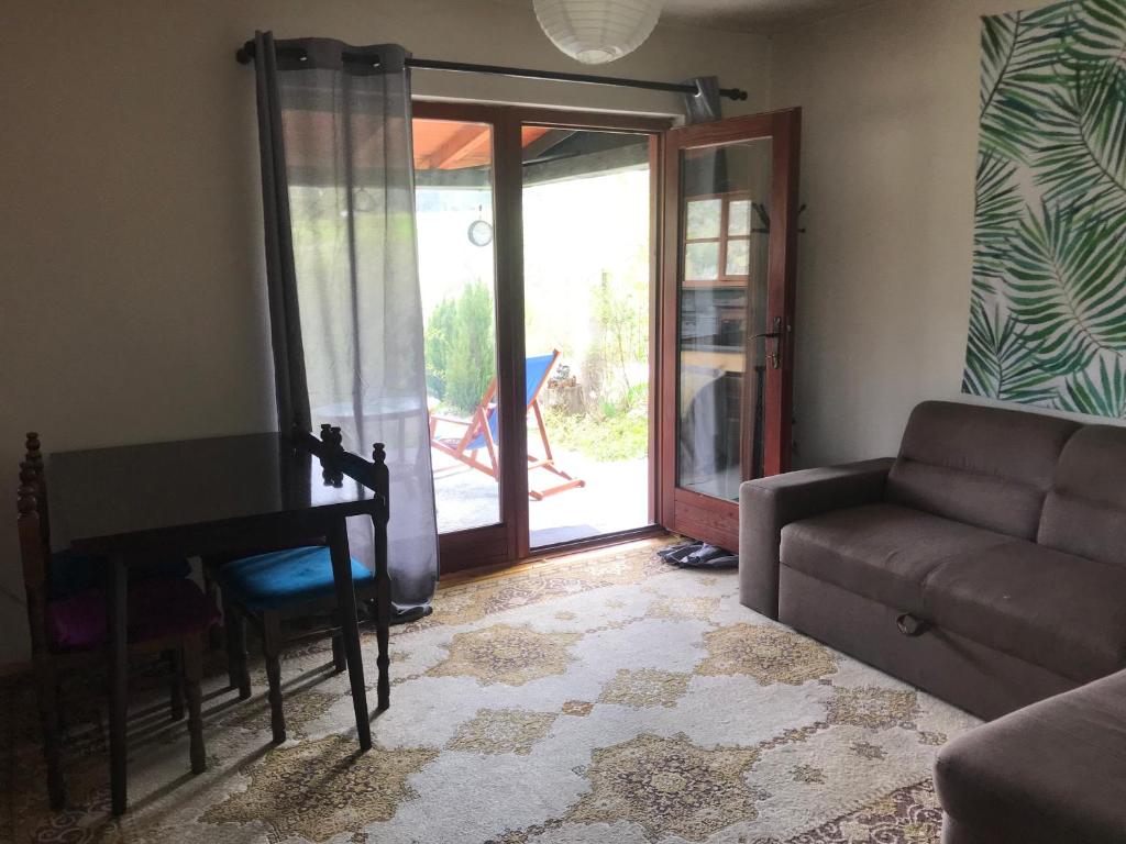 a living room with a couch and a table and a door at Kokin Brod Apartments in Kokin Brod