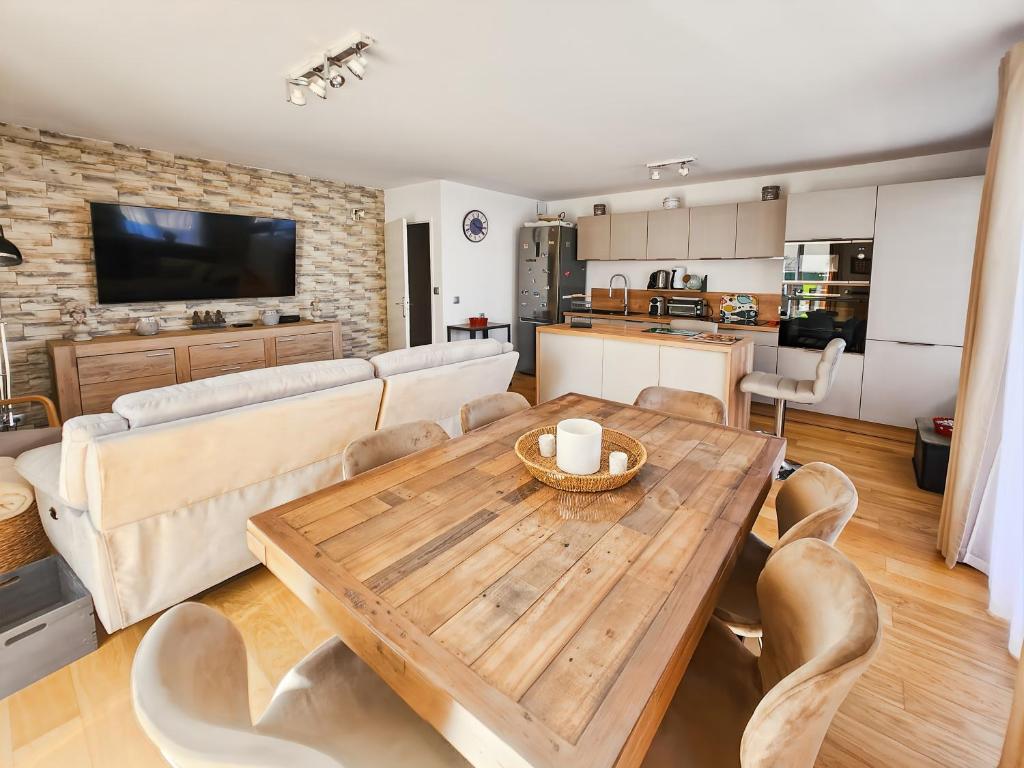 Il dispose d'une cuisine et d'un salon avec une table et des chaises en bois. dans l'établissement Appartement cosy près Disney, jardin & terrasse, à Magny-le-Hongre