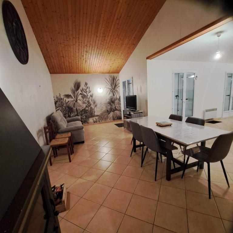 un salon avec une table, des chaises et un canapé dans l'établissement oh bonheur de l'ocean, à Bretignolles-sur-Mer