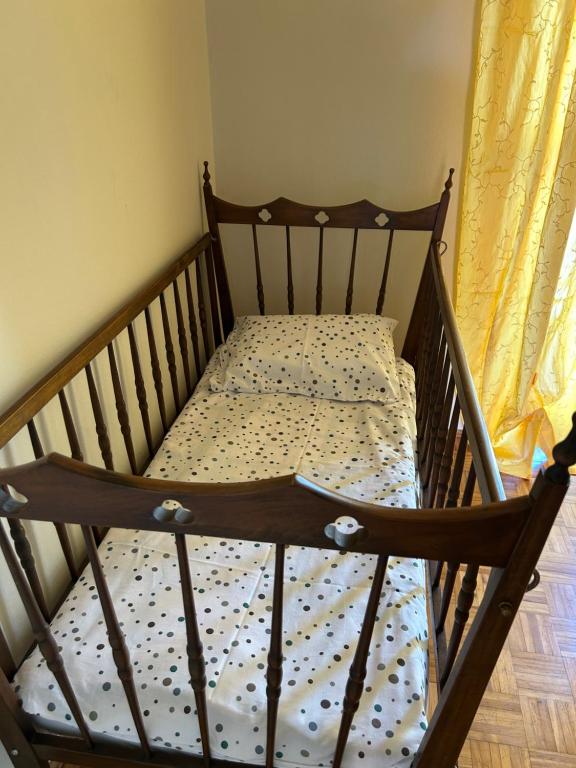 a wooden bed in a room with a crib at Casa Flora in Biella