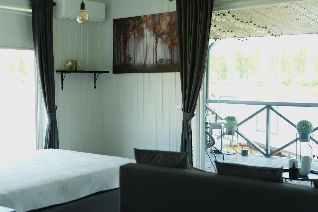 une chambre avec un lit et une vue sur un balcon dans l'établissement DeerHouse, à Kaliakiemiai