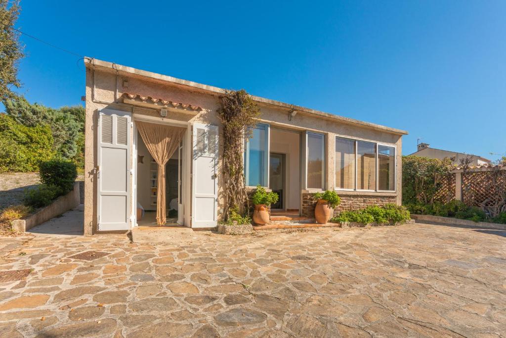 une maison avec une porte blanche sur une allée en pierre dans l'établissement Villa de la brune proche plages, à Bormes-les-Mimosas