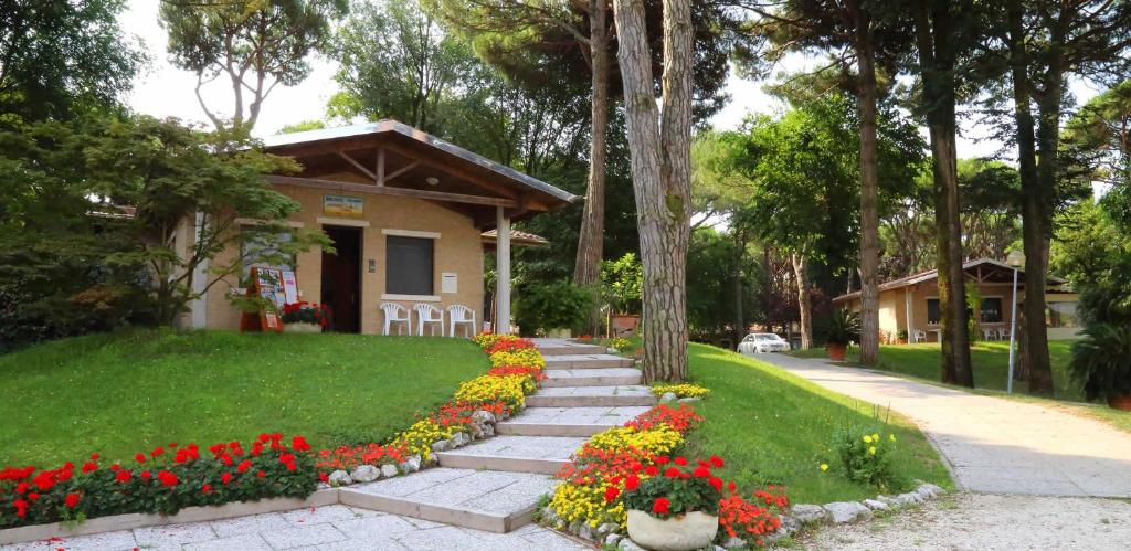 a small house with flowers in front of it at Villaggio California in Eraclea Mare