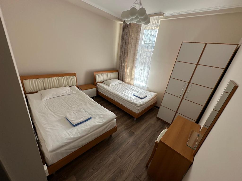 a small bedroom with two beds and a window at Антей Большой in Koshkolʼ
