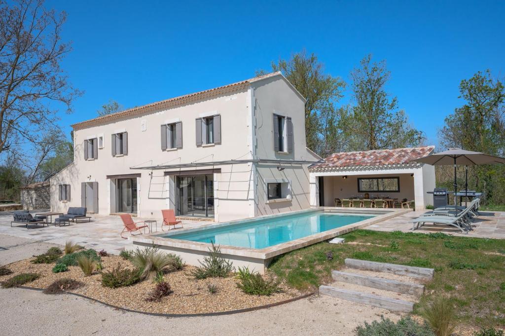 une maison avec une piscine devant dans l'établissement Mas de l' écluse, à Maussane-les-Alpilles