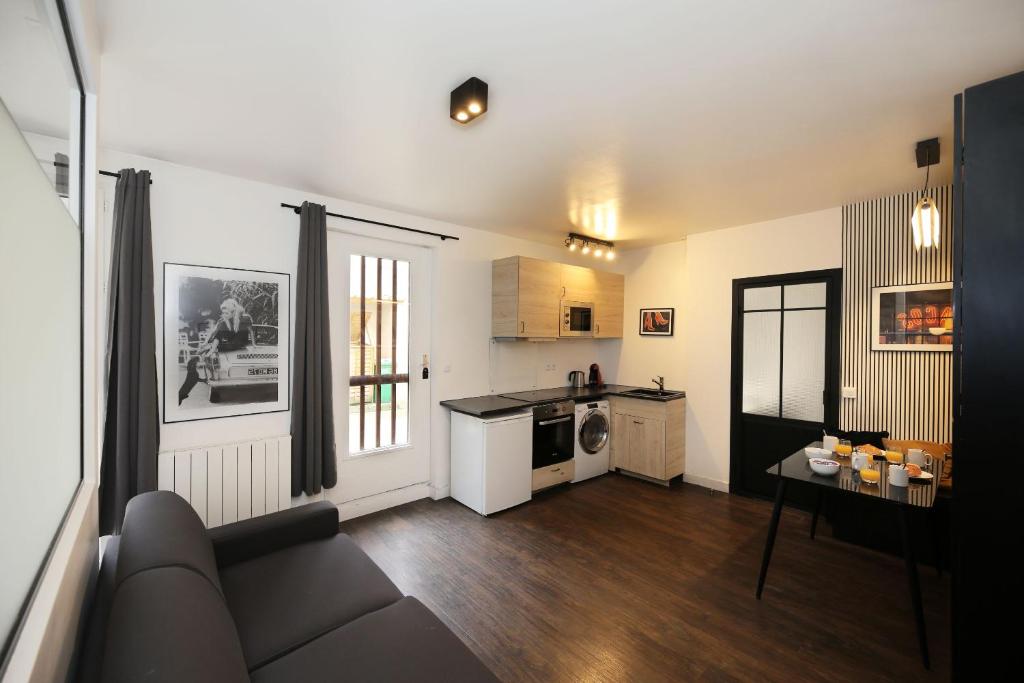un salon avec un canapé et une cuisine dans l'établissement Appartement Paris 13 universite - 4P RDC, à Paris